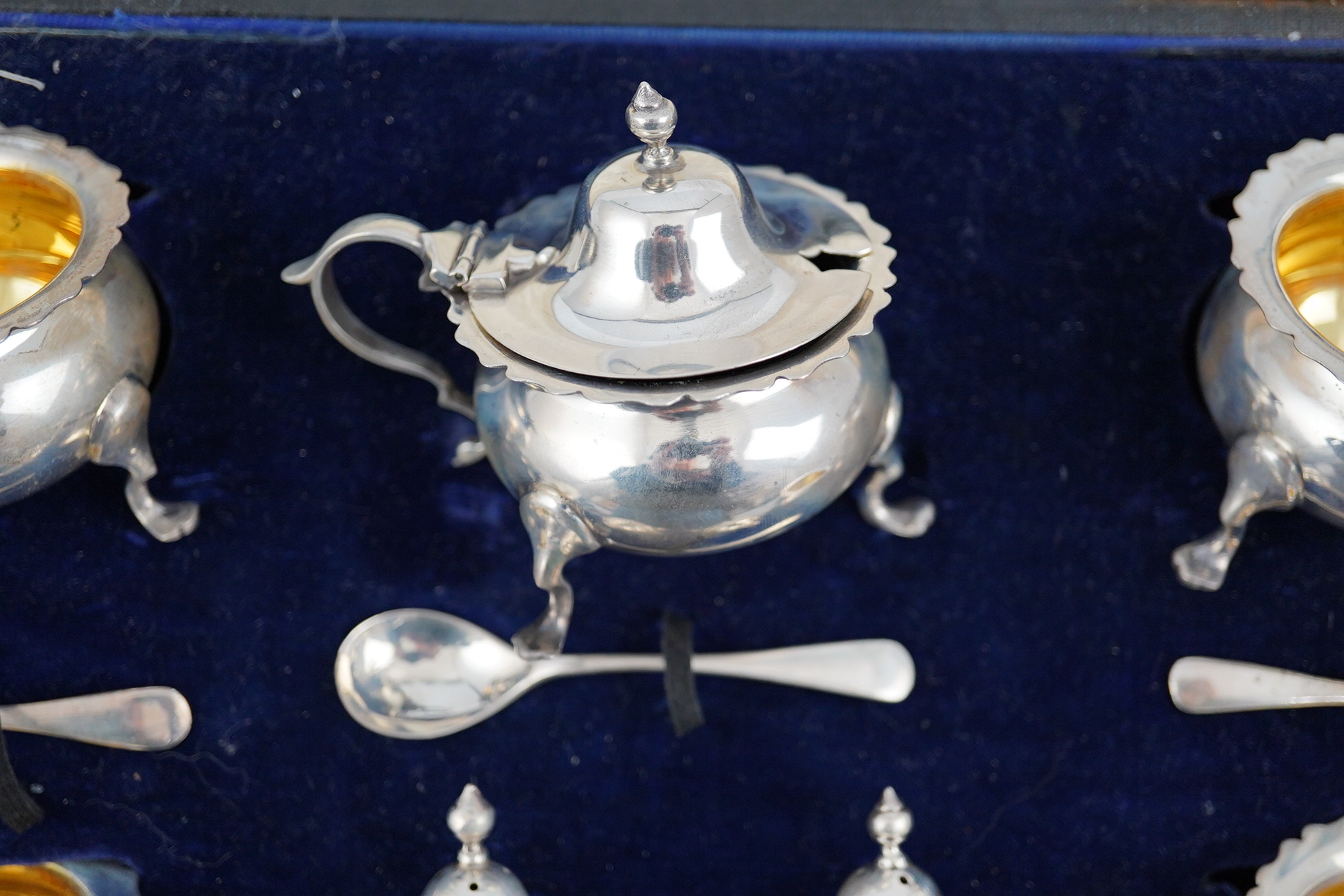 A George V cased silver seven piece condiment set by Horace Woodward & Co Ltd, Birmingham, 1918, with five associated silver condiment spoons. Condition - poor to fair
